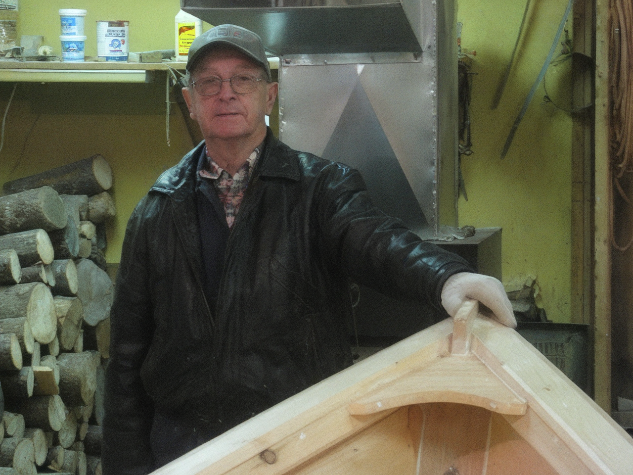 Wilbert Weir in his workshop, standing between two hand-built Grand Banks dories