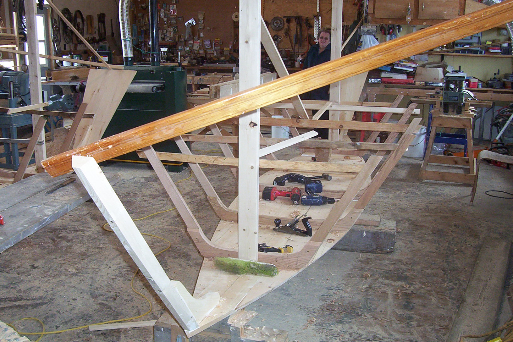 Workshop tools in use during dory construction - drilling, clamping, fitting